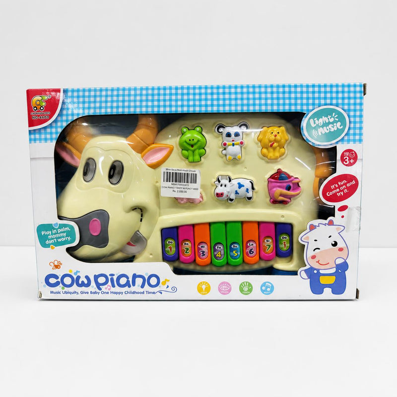 Cow Piano in the box window, cream cow head with eight coloured keys along its body
