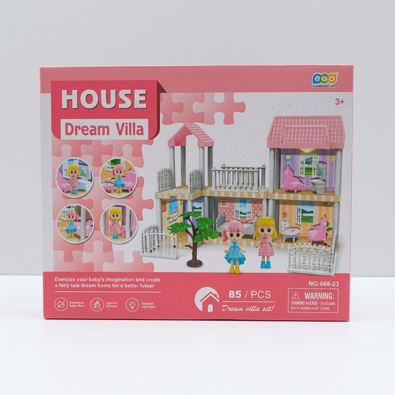 Dollhouse playset box front, pink-roofed two-storey Dream Villa with fence, tree and two doll figures, 3+ badge and warning