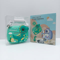 Teal dinosaur print camera with a paper roll and USB cable in its blister pack