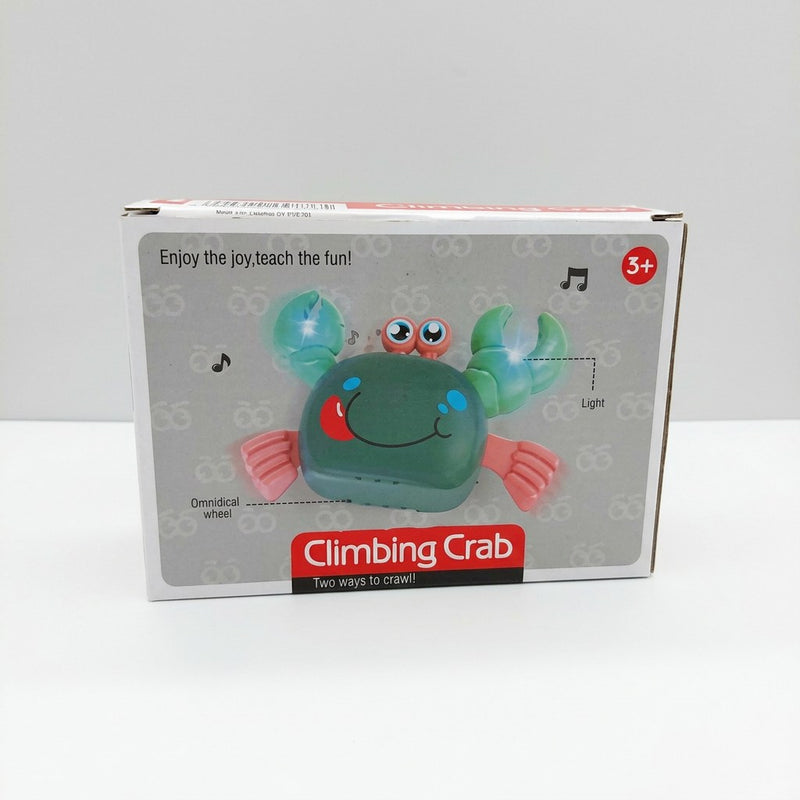 Climbing crab toy box front, green crab with pink claws, light and music-note icons, and a 3+ age badge