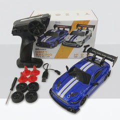 Blue 1:24 scale drift RC car with its remote control, four spare wheels, four traffic cones, a screwdriver and a USB charging cable