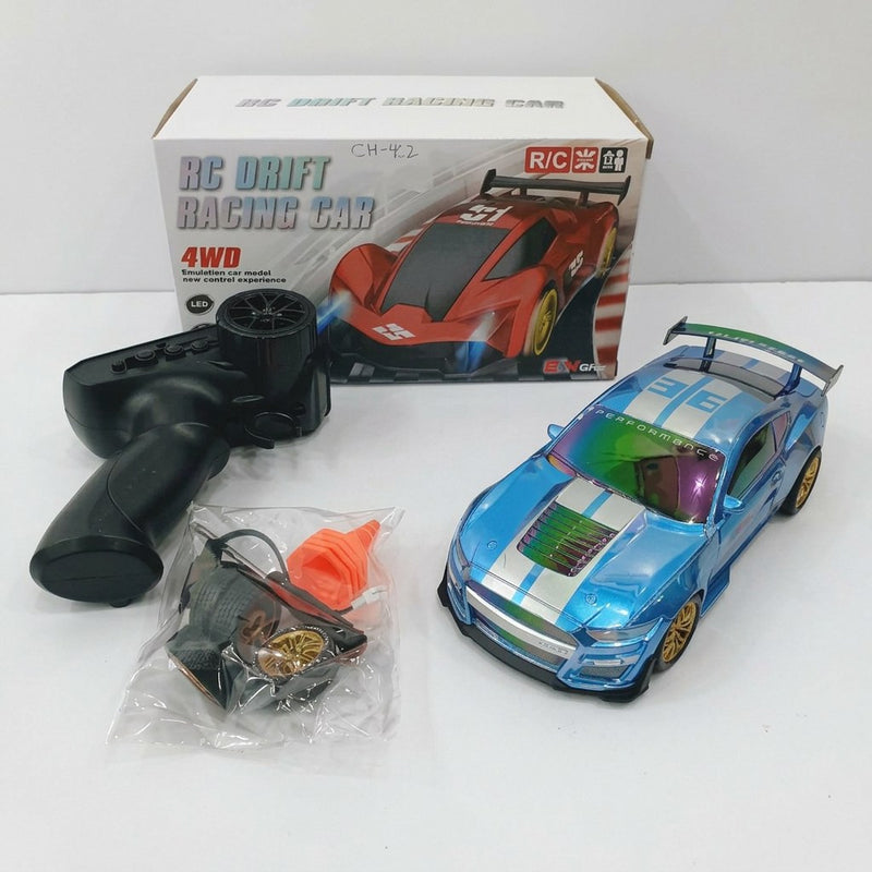 RC DRIFT RACING CAR 4WD box front, and the metallic blue drift car, remote control, spare wheel, traffic cone and USB cable laid out in front