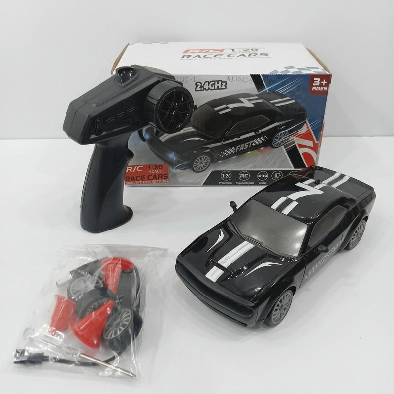 Black 1:20 RC rally race car numbered 7, with its pistol-grip controller, spare wheel, traffic cones and screwdriver, beside the "3+ AGES" box