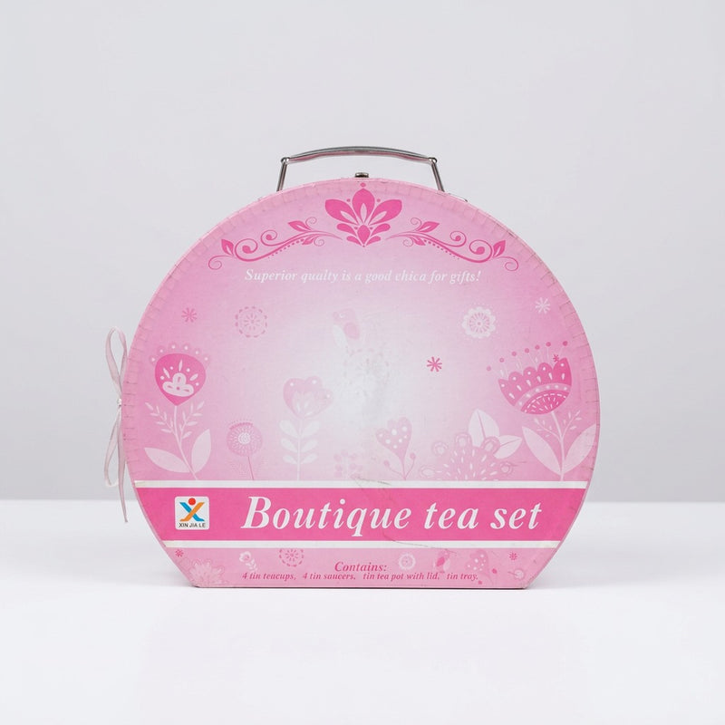 Close-up of the floral tin print on the saucers and teapot, with the shop price sticker