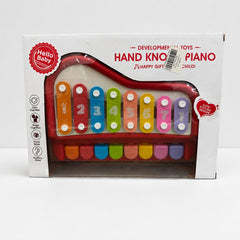 Hand knock piano in red and white inside its window box, eight numbered bars visible