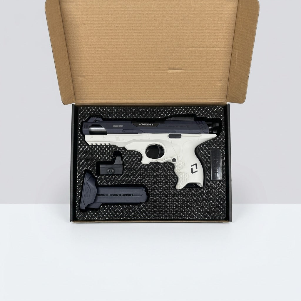 Open black box showing the white and grey toy pistol, a magazine and a sight block in foam
