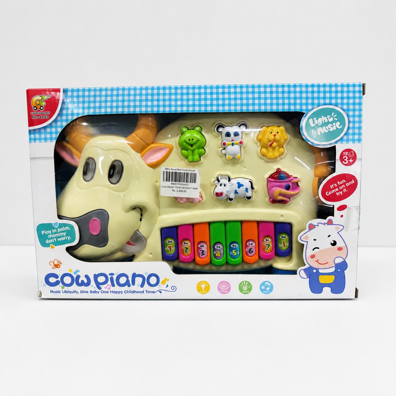 Cow Piano in the box window, cream cow head with eight coloured keys along its body
