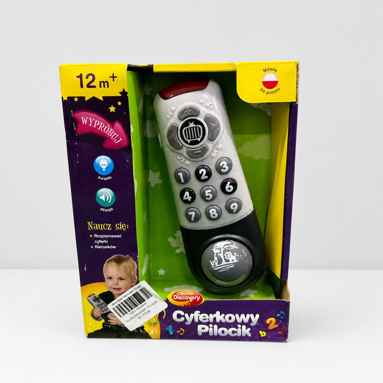 Cyferkowy Pilocik box front, grey and black toy remote control in an open window box