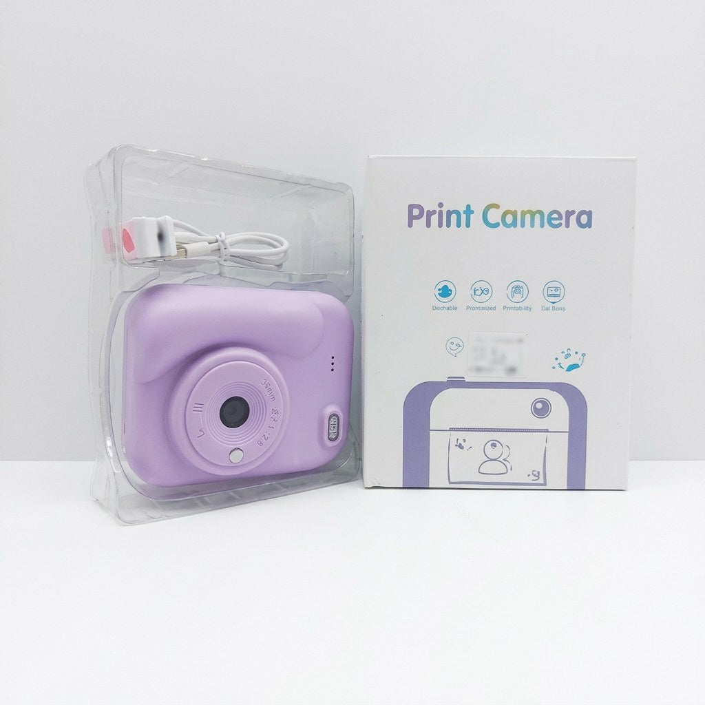 Lilac-purple kids' print camera with wrist strap, shown beside its retail box