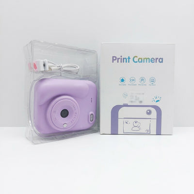 Lilac-purple kids' print camera with wrist strap, shown beside its retail box