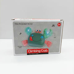 Climbing crab toy box front, green crab with pink claws, light and music-note icons, and a 3+ age badge