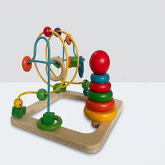 Wooden bead maze and ring stacker toy beside its box, blue and yellow wire loops with coloured beads, red ball-topped ring stacker alongside