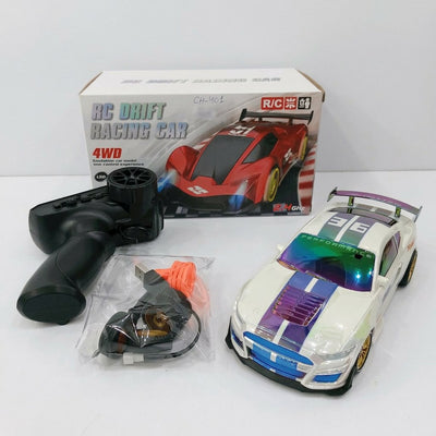 RC DRIFT RACING CAR 4WD box front, and the white and blue drift car, remote control, spare wheel, traffic cone and USB cable laid out in front