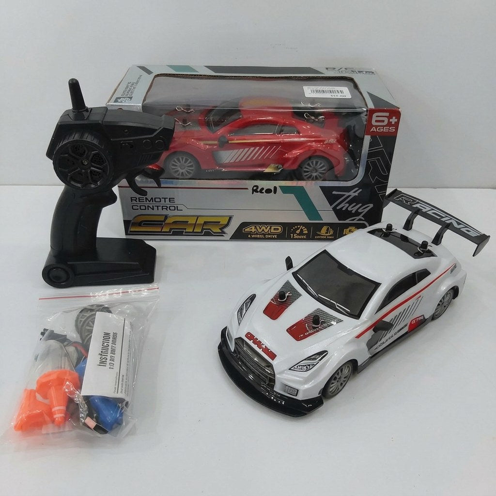Remote Control Car Racing box front with the 6+ age mark and 4WD / 15 km/h feature icons, and the white GTR-badged car, remote control, spare wheel, cone and battery pack laid out in front