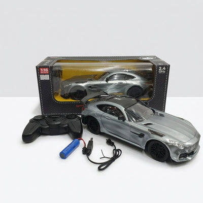 Silver 1:16 scale RC sports car in its window box, with the remote control, rechargeable battery pack and charging lead