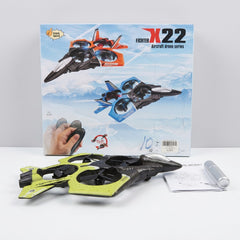 The yellow and black drone with its hand remote and folded manual in front of the box