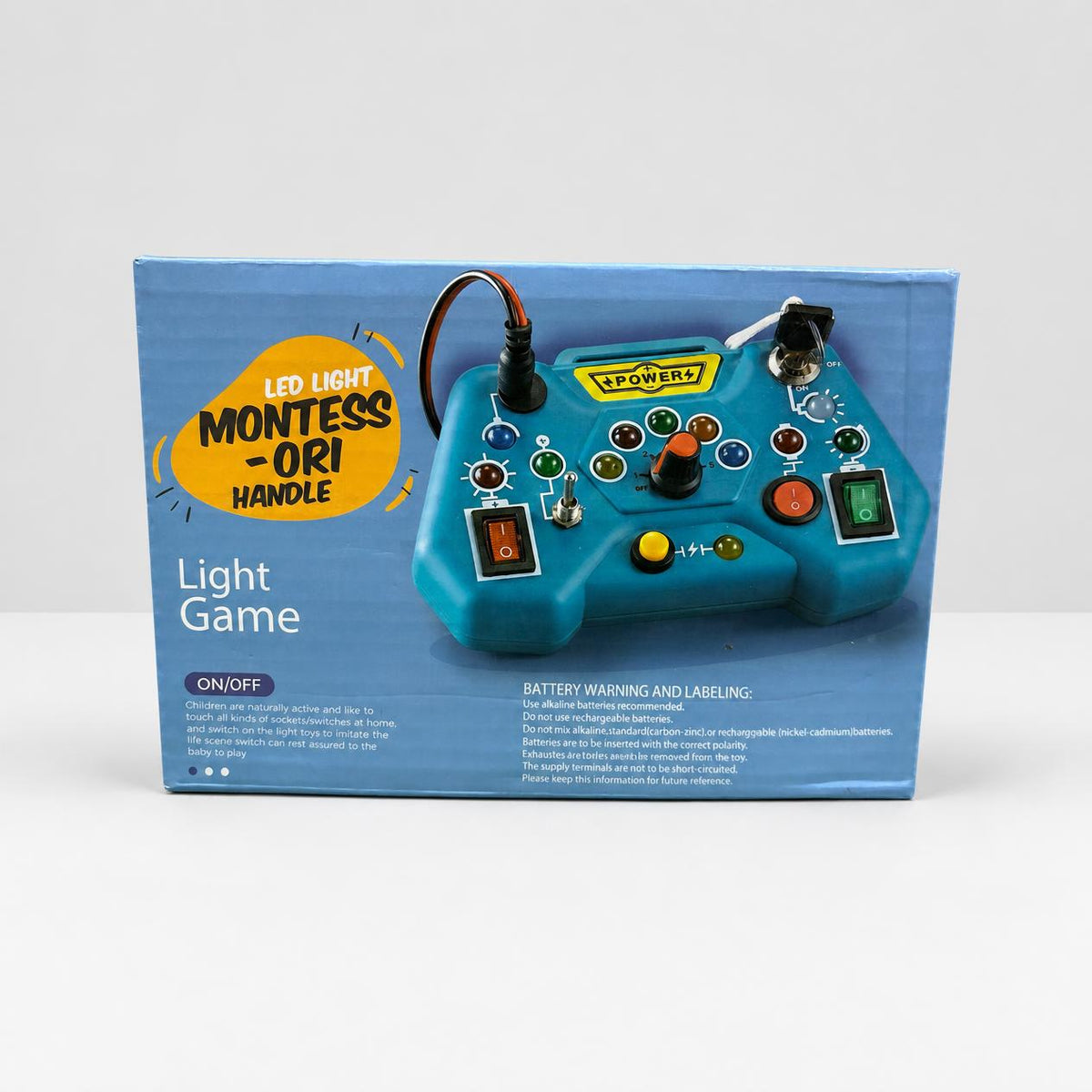 Montessori Handle box front, teal handle with rocker switches, a key, a dial and a plug-and-jack