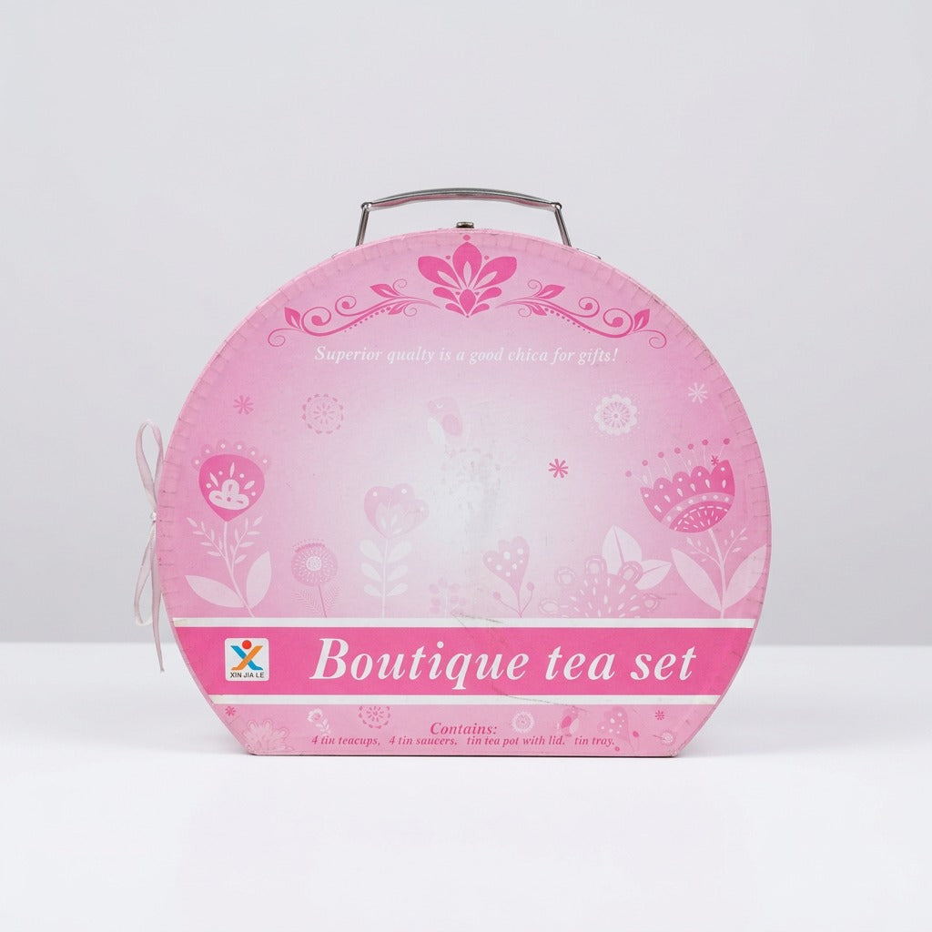 Close-up of the floral tin print on the saucers and teapot, with the shop price sticker