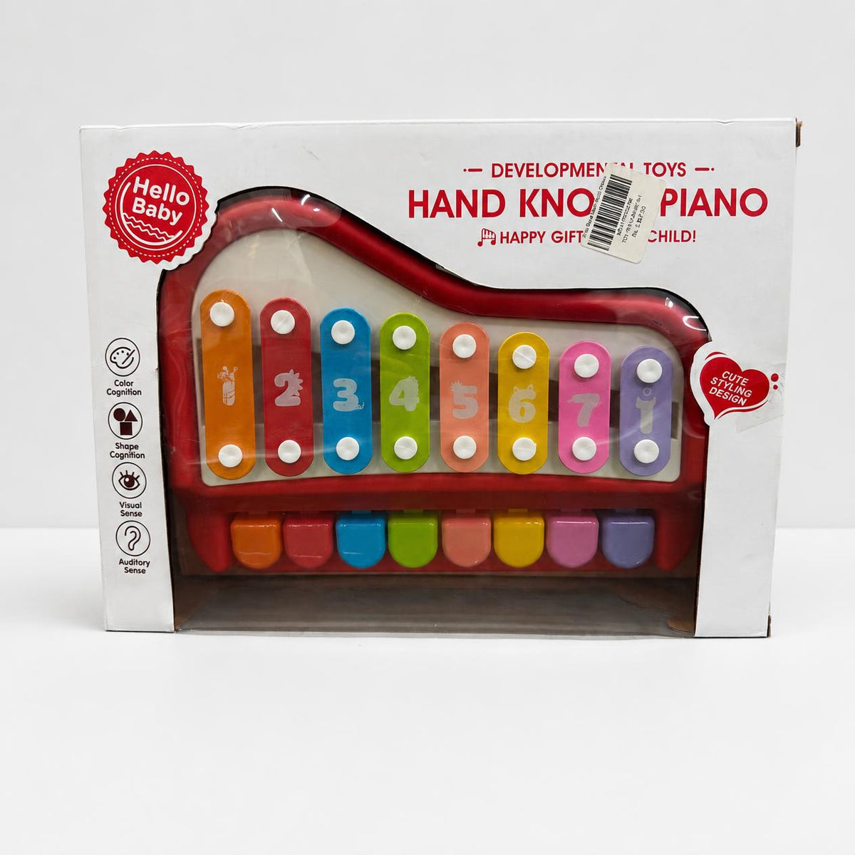 Hand knock piano in red and white inside its window box, eight numbered bars visible